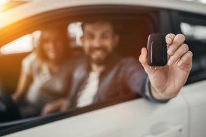 Happy,Beautiful,Couple,Is,Choosing,A,New,Car,At,Dealership.
